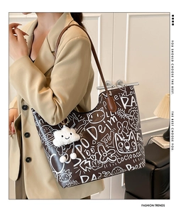 Borsa tote marrone con graffiti e ciondolo a nuvola indossata a spalla in scena lifestyle