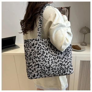 Gros plan sur un sac cabas en velours léopard avec grande capacité et poche frontale