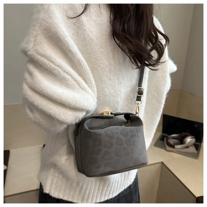 Détail du sac bandoulière gris à motif léopard avec finitions métalliques dorées