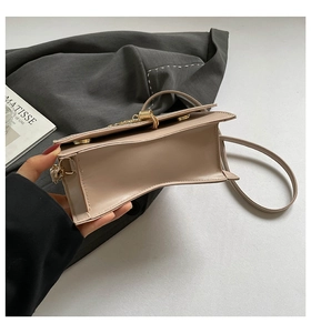 Detailed top view of the beige leather handbag interior with golden clasp and slim strap