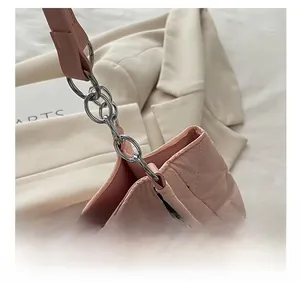 Detail of silver chain link and pink quilted nylon texture on tote shoulder bag