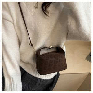 Detailed view of brown leopard print crossbody bag with metal buckle and suede texture