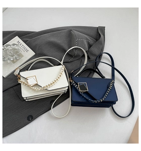 Detail of white and blue woven chain handbags with metallic square buckle on a grey background