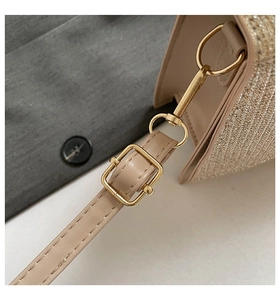 Detail of adjustable pale gold buckle and glitter fabric stitching on the beige shoulder bag