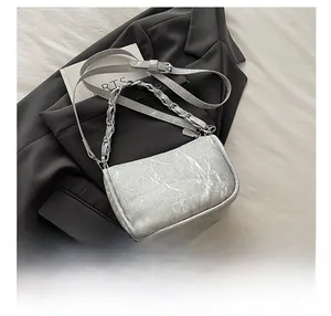 Détail du sac bandoulière gris à motif marbre avec chaîne métal et cuir