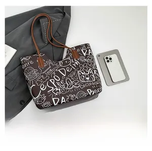 Dettaglio della borsa tote marrone con motivi scarabocchio bianchi e finta pelle resistente