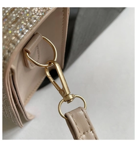 Detailed close-up of beige sequin shoulder bag featuring lychee grain leather and gold hardware