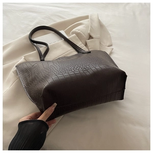 Detailed texture of dark brown crocodile-embossed faux leather large tote bag
