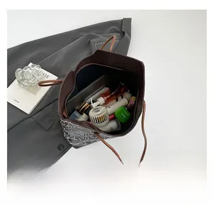 Dettaglio della grande capacità della borsa tote marrone con graffiti e oggetti vari