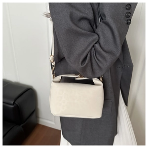 Close-up of cream leopard print crossbody bag with gold hardware and wrinkled texture