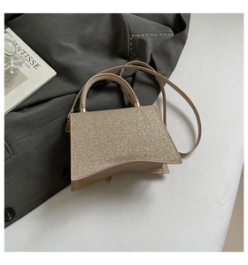 Detail of champagne gold glitter crossbody bag with arched base and golden hardware
