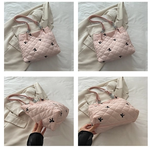 Detail of pink quilted tote bag featuring black embroidered bows and soft texture