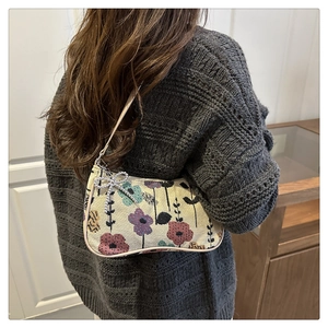 Close-up of floral jacquard crescent bag with silver bow accent and crystal beads