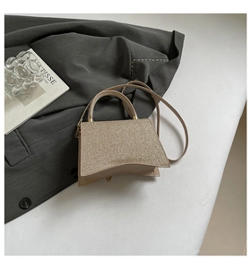 Detail of champagne gold sequin handbag with curved base and fine glitter finish