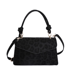 Luxury black leopard print handbag with knotted handle and gold hardware on white background