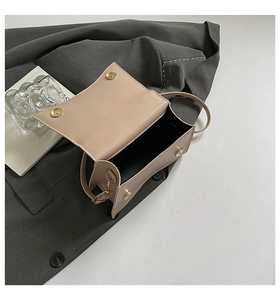 Close-up of beige crossbody bag showing the magnetic gold clasp and smooth PU leather texture