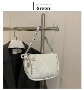 Détail du sac à main vert menthe à motif marbre avec nœud perlé et chaîne argentée