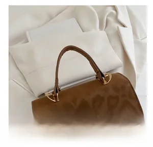 Detail of leopard print embossed texture and golden metal twist lock on the brown bag