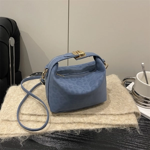 Sac à main carré bleu à relief léopard et détails dorés sur fond en maille beige