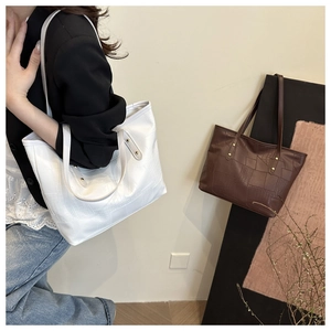 Detail view of large tote bag with crocodile texture stitching in white and coffee