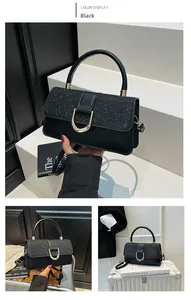 Detail of black sequin handbag with gold U-shaped buckle and textured glitter leather
