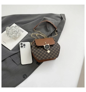 Détail du sac hexagonal avec motif monogramme et pendentif chat doré élégant