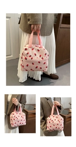 Close-up of pink corduroy tote bag featuring red strawberry prints and zipper closure
