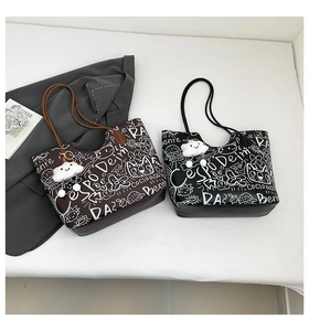 Dettaglio di borse tote con stampa graffiti cartoon e ciondoli a forma di nuvola
