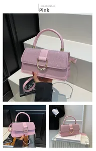 Macro detail of pink handbag with shimmering glitter flap and gold U-shaped buckle