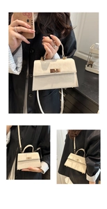 Details der cremeweißen Retro-Tasche mit Ledertextur und goldenem Metallverschluss