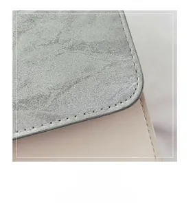 Detailed view of silver marble texture stitched with smooth cream leather on a handbag