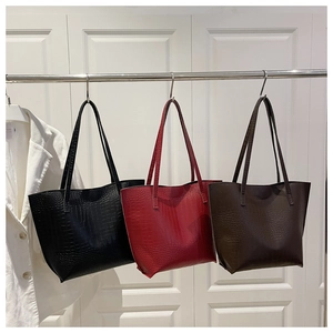 Macro shot of three minimalist tote bags featuring premium crocodile embossed texture and finish