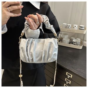 Détail du sac nuage plissé argenté avec lettres dorées et bandoulière en chaîne