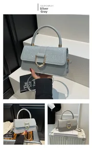 Detail of silver sequined handbag with gold horseshoe clasp and sleek leather finish