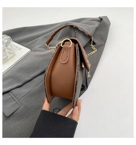 Détail du sac bandoulière marron vintage avec chaîne dorée et finition texturée