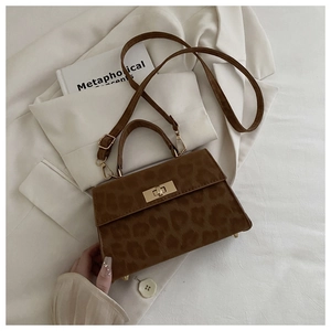 Detail der Vintage-Handtasche mit Leopardenmuster, goldenem Drehverschluss und Schultergurt