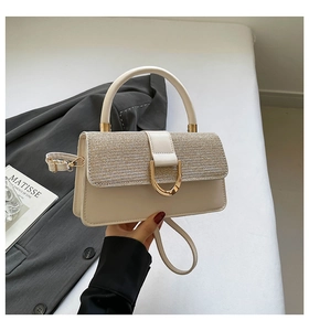 Detail of champagne gold glitter flap and D-shaped metal buckle on cream handbag