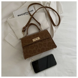 Detailansicht der Leoparden-Handtasche mit goldenem Drehverschluss und Größenvergleich