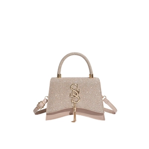 Champagne glitter crossbody bag with gold S logo and fringe on a white background