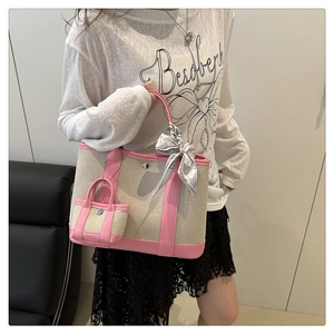Detail of pink leather trim on canvas tote with silk scarf and mini pouch accessory