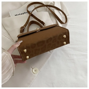 Detail der Leoparden-Handtasche mit goldenen Boden-Nieten und texturierter Kunstleder-Optik