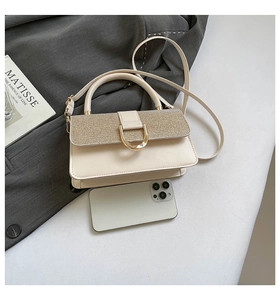 Detail of a beige sequined shoulder bag with gold D-ring buckle and sleek PU leather finish