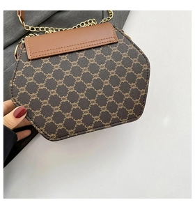 Détail du sac bandoulière hexagonal marron avec motif chaîne rétro et chaîne dorée