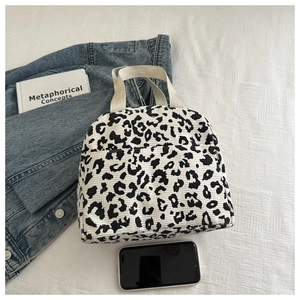 Detail view of the black and white leopard print corduroy lunch bag with fabric handles
