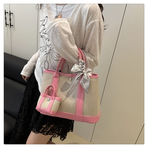 Detail of canvas tote bag with pink leather trim, floral scarf and mini charm accessory