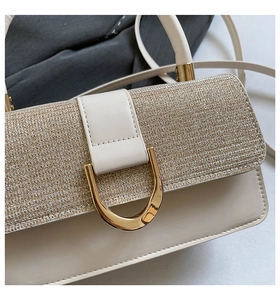 Detailed close-up of golden glitter flap and polished metal U-shaped lock on the bag