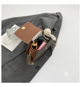 Vue de dessus d'un sac bandoulière marron montrant le rangement pour les essentiels