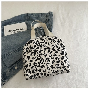 Macro detail of leopard print corduroy lunch bag with white durable webbing handles