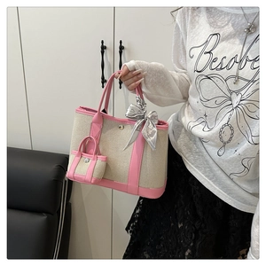 Detail of beige canvas and pink leather tote bag with small pouch and decorative scarf