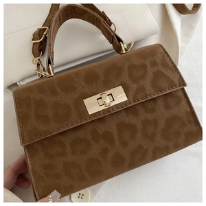 Nahaufnahme der Handtasche mit Leopardenmuster, goldenem Drehverschluss und Lederstruktur